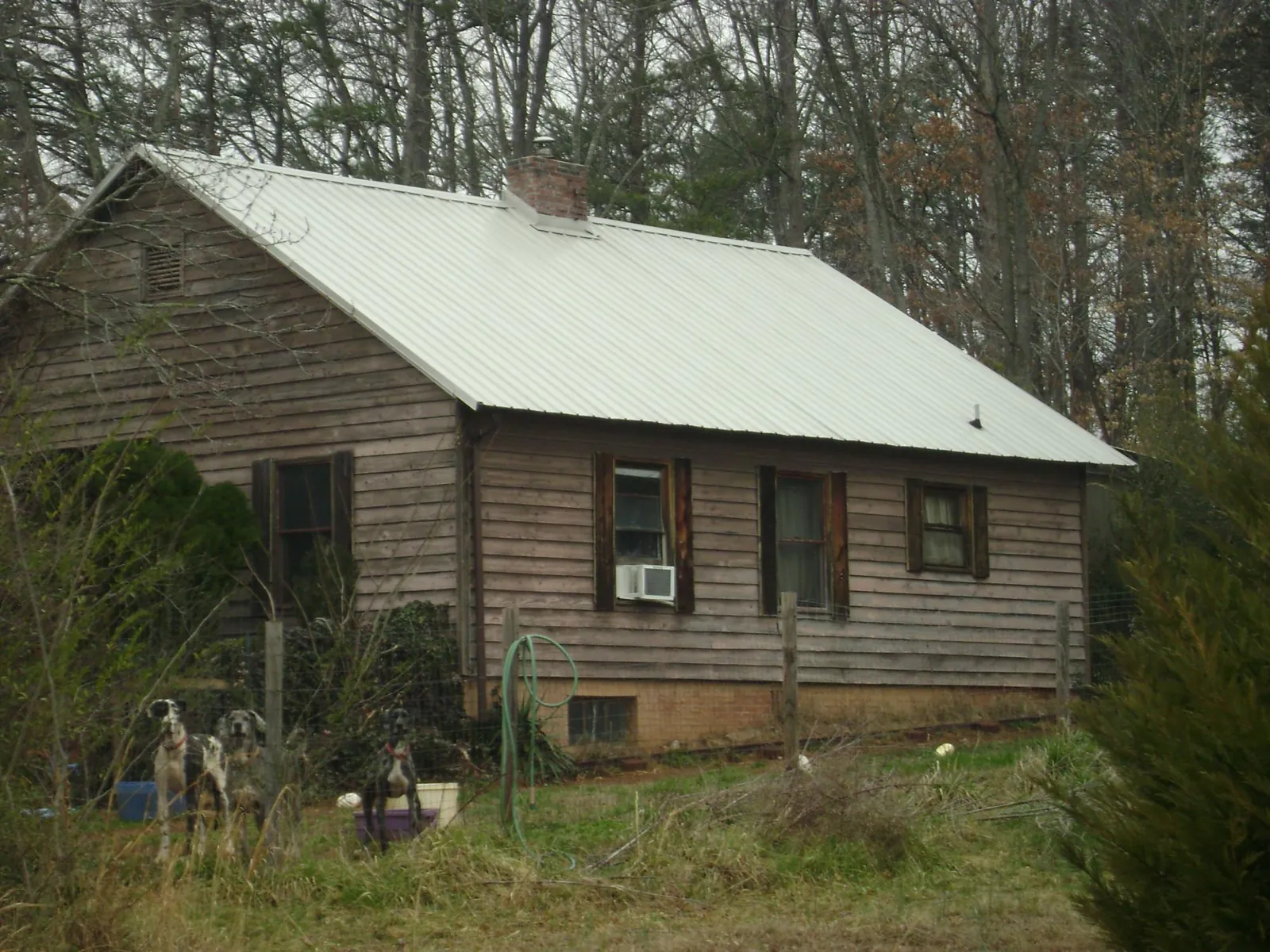 White metal roof on an old wood sided farmhouse, from a Metal Roof Installation job in Covington